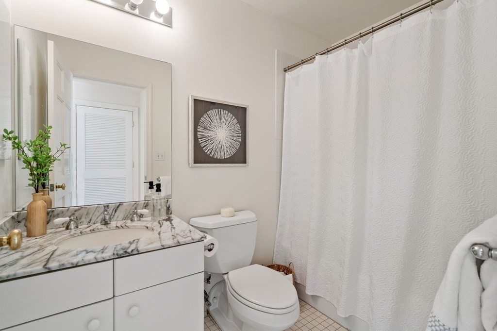 197 8th Street, Unit 330 Boston, MA 02129 - Photo 17 of 39 a bathroom with a granite countertop sink mirror vanity and toilet