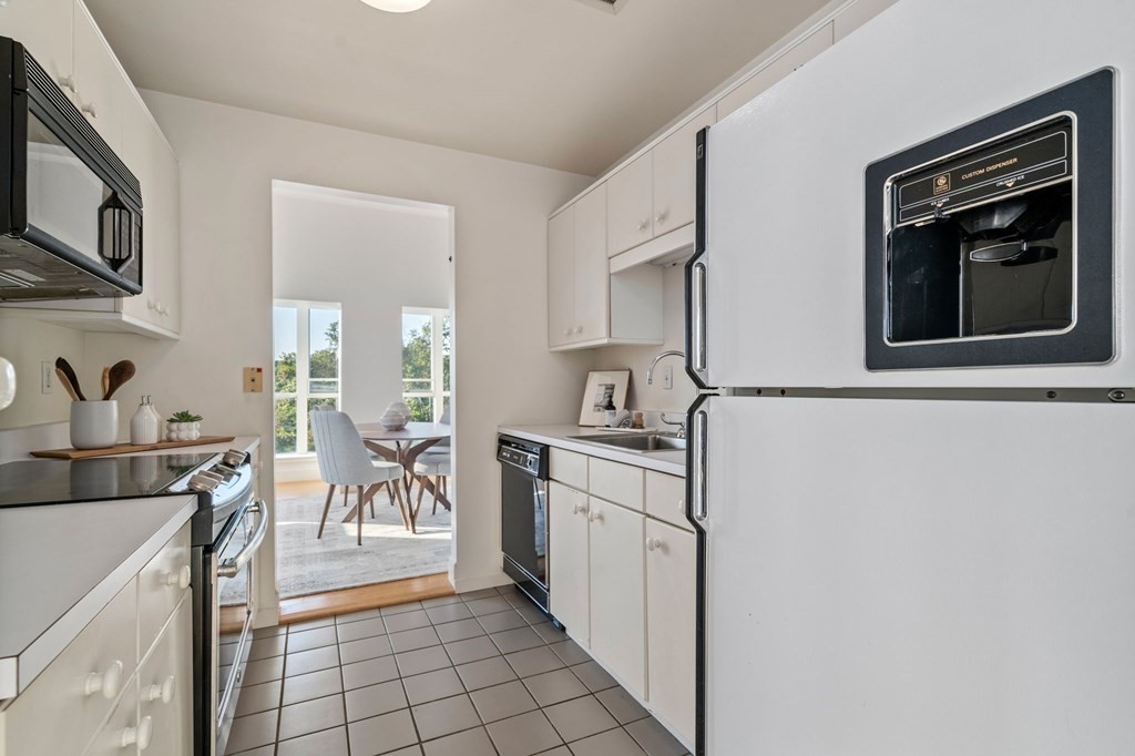 197 8th Street, Unit 330 Boston, MA 02129 - Photo 19 of 39 a kitchen with stainless steel appliances granite countertop a stove a sink and a microwave