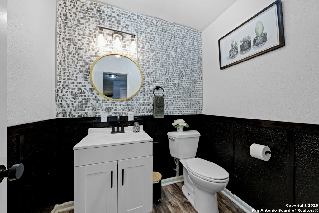 1510 Timmermann Road Seguin, TX 78155 - Photo 13 of 32 a bathroom with a toilet sink vanity and mirror