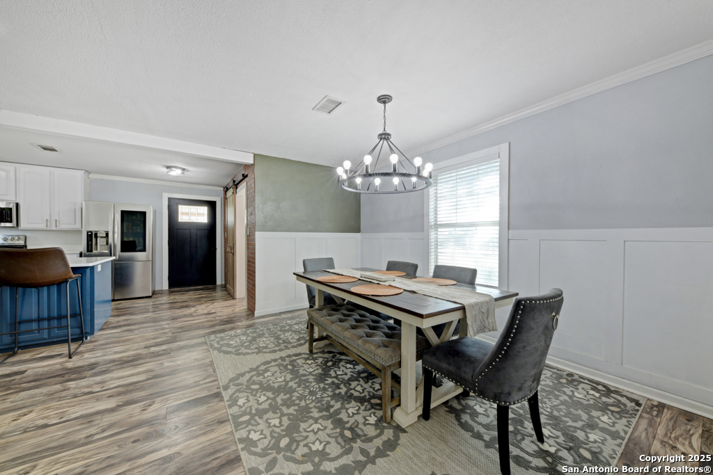 1510 Timmermann Road Seguin, TX 78155 - Photo 6 of 32 a view of a dining room with furniture a chandelier and wooden floor