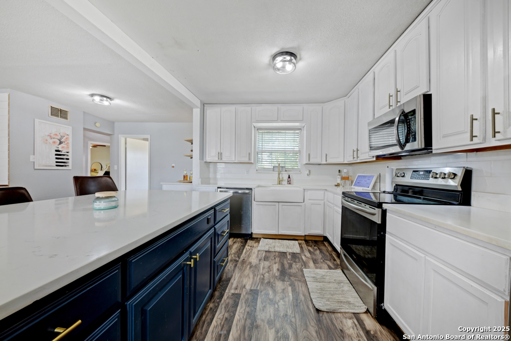 1510 Timmermann Road Seguin, TX 78155 - Photo 8 of 32 a kitchen with stainless steel appliances white cabinets sink and stove