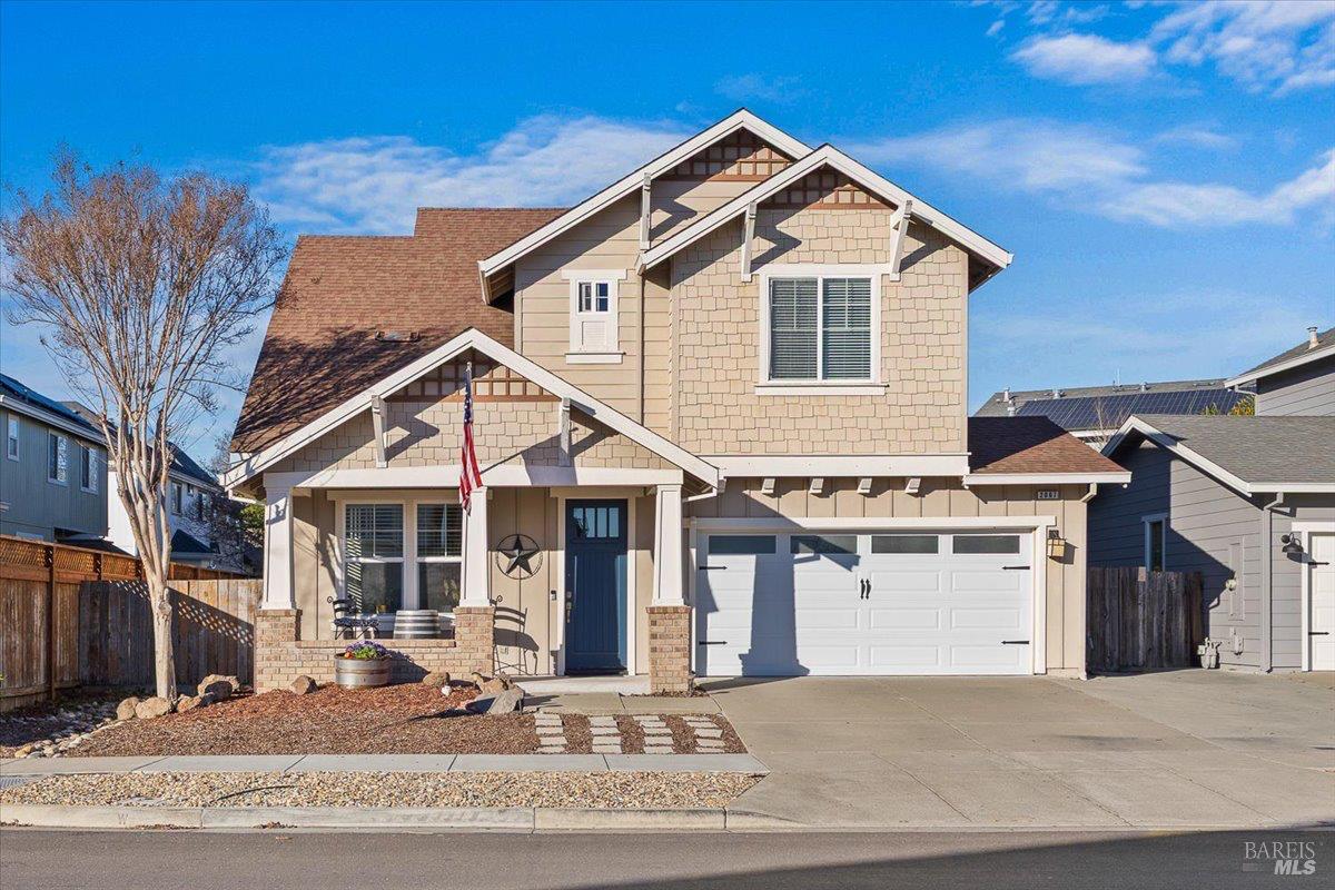 a view of a white house with a sink and dishwasher next to a yard