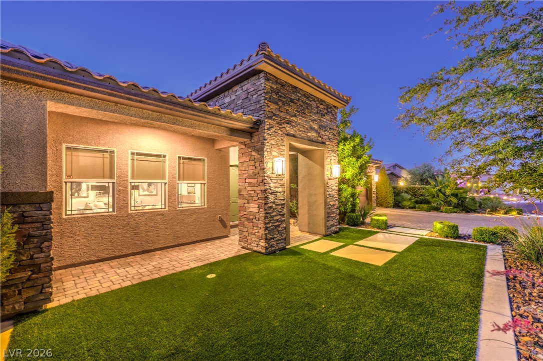 7119 Arabian Ridge Street Las Vegas, NV 89131 - Photo 57 of 73 Stone accents and manicured synthetic turf elevate this home's entrance.