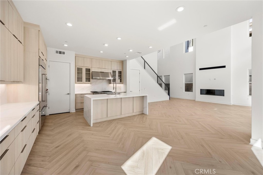 164 Apron Irvine, CA 92618 - Photo 19 of 67 a large white kitchen with stainless steel appliances kitchen island granite countertop a refrigerator and a stove top oven