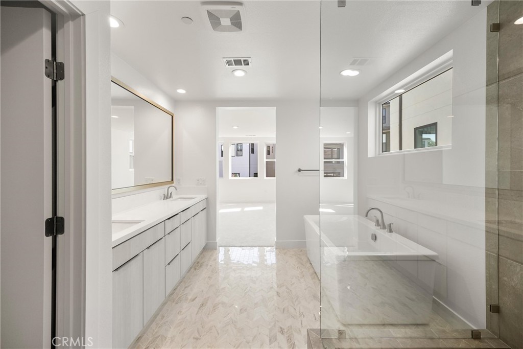 164 Apron Irvine, CA 92618 - Photo 32 of 67 a bathroom with a tub a sink and mirrors