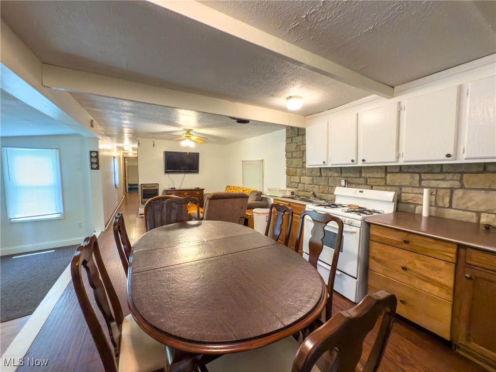 36475 Kinney Ridge Road Woodsfield, OH 43793 - Photo 15 of 50 Dining room with ceiling fan, a textured ceiling, beam ceiling, and dark carpet