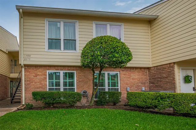 a front view of a house with a yard and plants