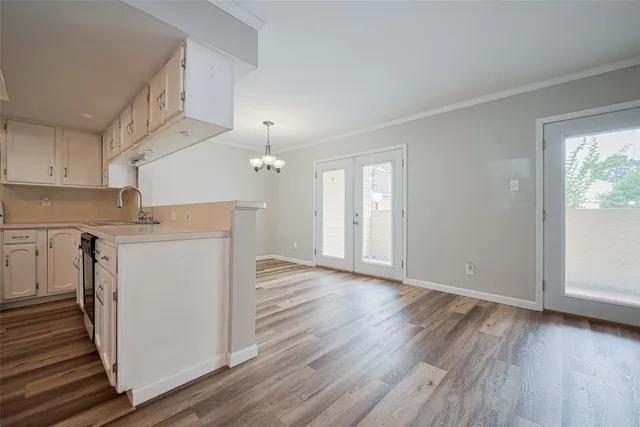a view of empty room with wooden floor and chandelier