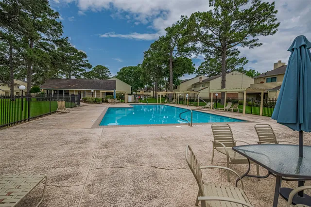 a view of backyard with swimming pool and seating space