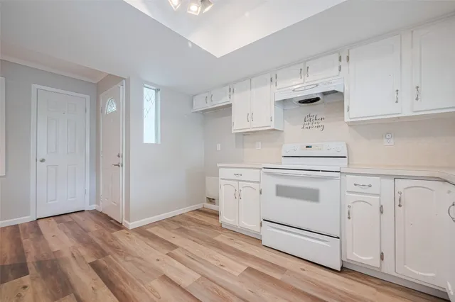 a kitchen with white cabinets and white appliances