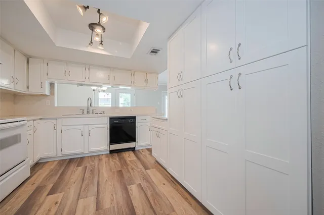 a kitchen with cabinets and wooden floor