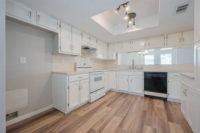 a kitchen with white cabinets stainless steel appliances