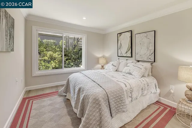 a bedroom with a bed and a painting on the wall