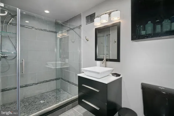 a bathroom with a shower sink and mirror