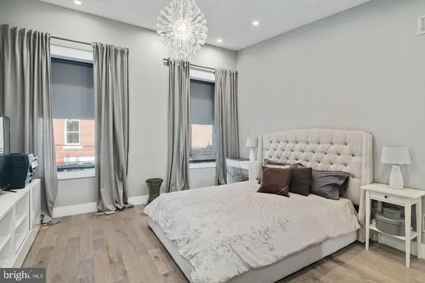 a bedroom with a large bed and a chandelier