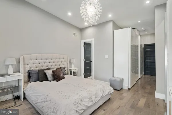 a bedroom with a large bed and a chandelier