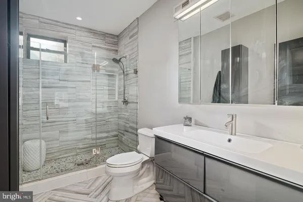 a bathroom with a sink a toilet and shower
