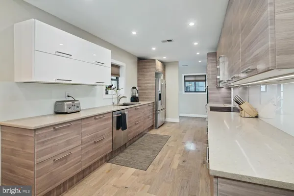 a large kitchen with stainless steel appliances kitchen island granite countertop a sink and cabinets