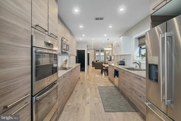 a large kitchen with stainless steel appliances and refrigerator
