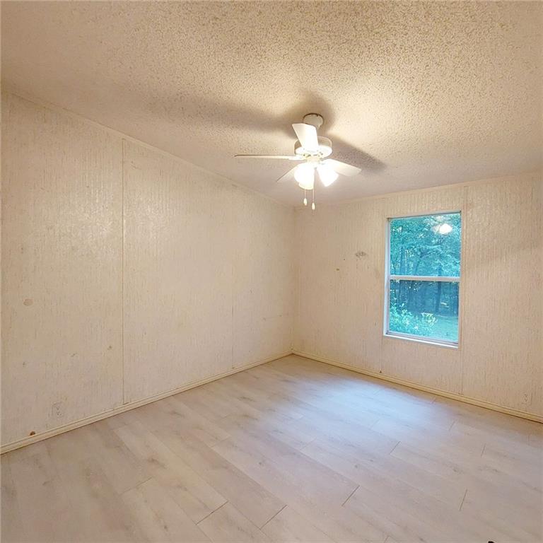 281 Mockingbird Drive Monticello, GA 31064 - Photo 22 of 42 an empty room with a chandelier fan and windows