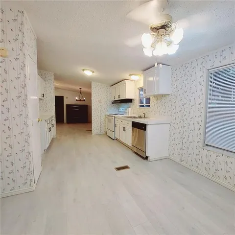 a large kitchen with cabinets and stainless steel appliances