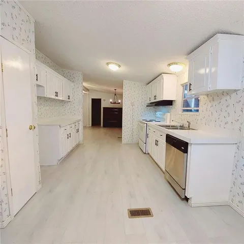 a kitchen with white cabinets and white appliances
