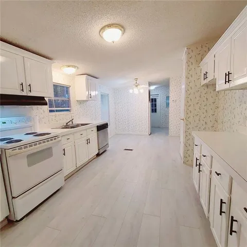 a kitchen with white cabinets and white appliances
