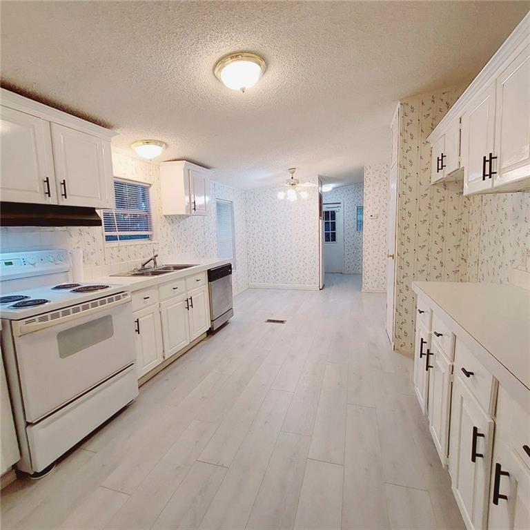 281 Mockingbird Drive Monticello, GA 31064 - Photo 8 of 42 a kitchen with white cabinets and white appliances