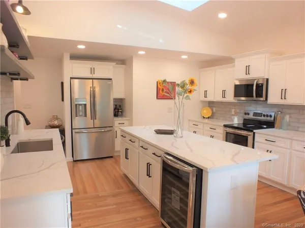 a kitchen with stainless steel appliances a refrigerator sink and microwave
