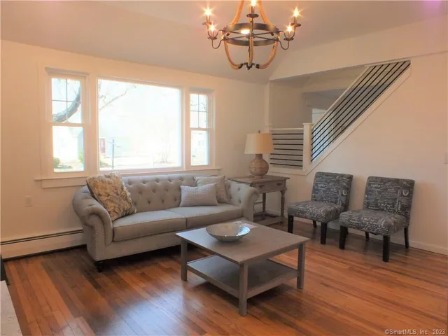 a living room with furniture wooden floor and window