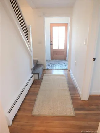 a view of a hallway with wooden floor and staircase