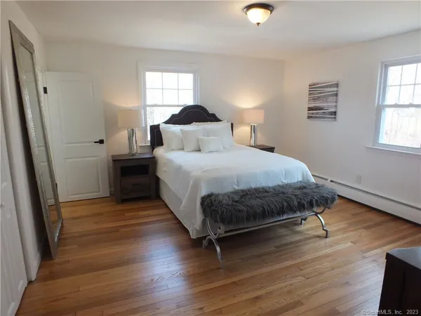 a bedroom with a bed and wooden floor