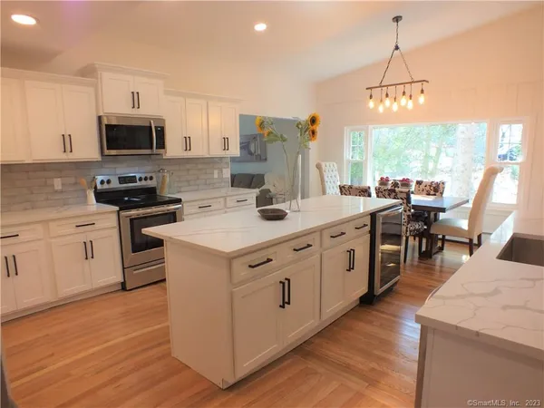 a kitchen with appliances a sink and cabinets