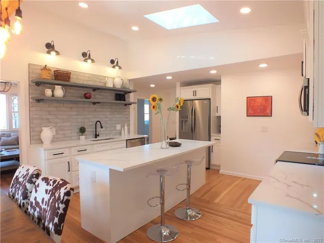 a large white kitchen with a sink and cabinets