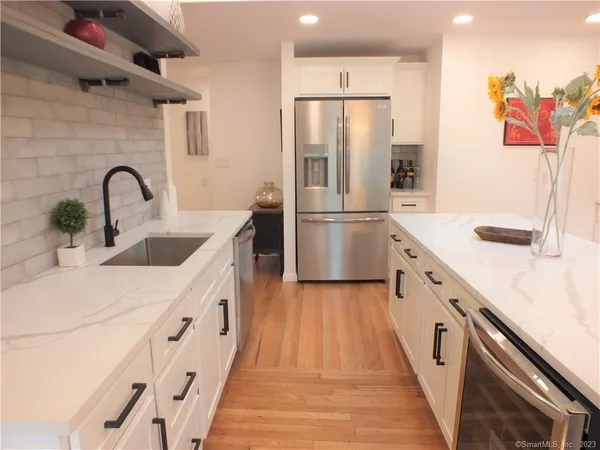 a kitchen with granite countertop a refrigerator and a sink