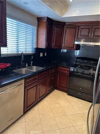 a kitchen with granite countertop wooden cabinets and a stove top oven