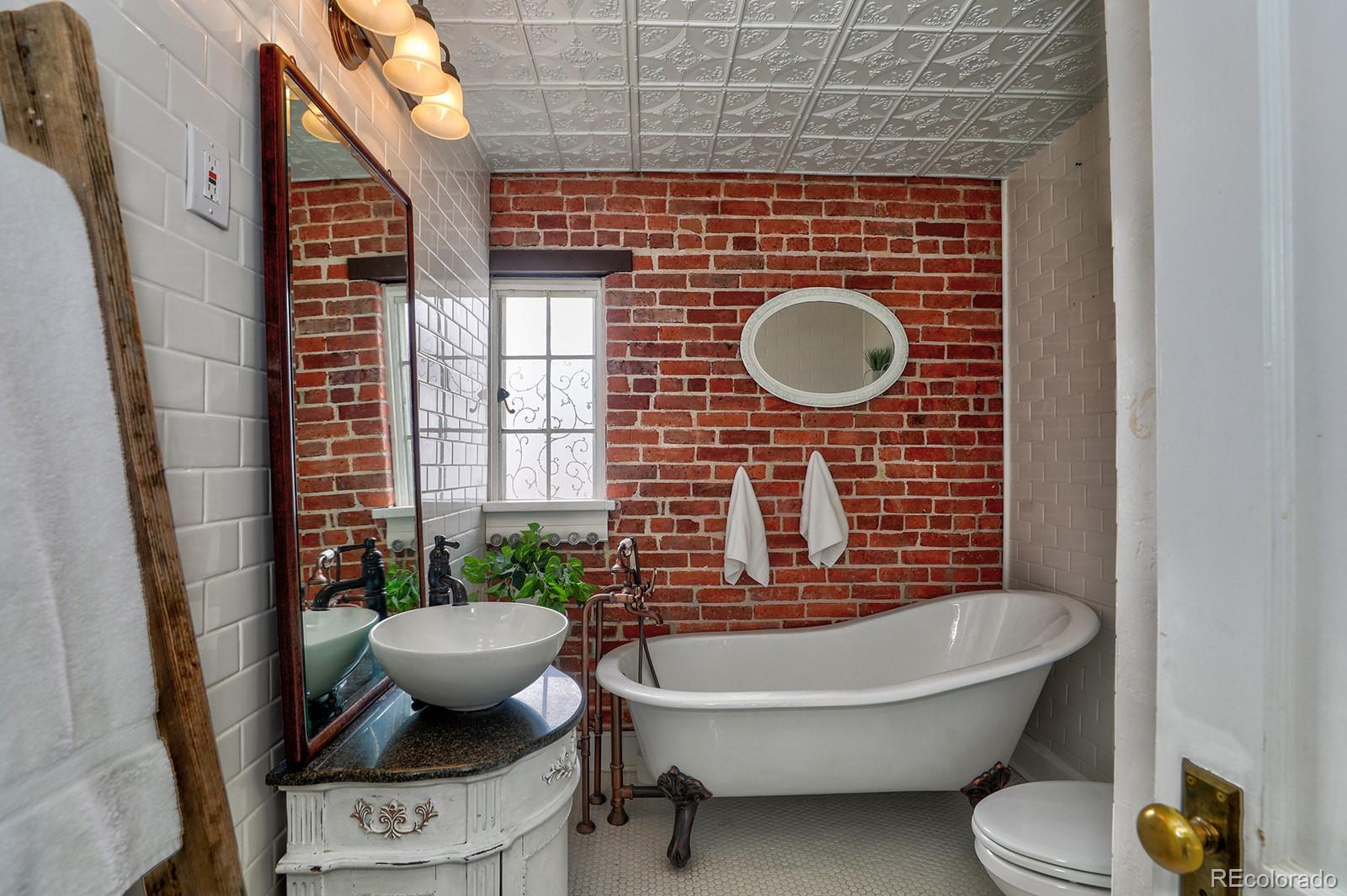3917 Haddon Road Denver, CO 80205 - Photo 20 of 40 a bathroom with a toilet a sink and mirror
