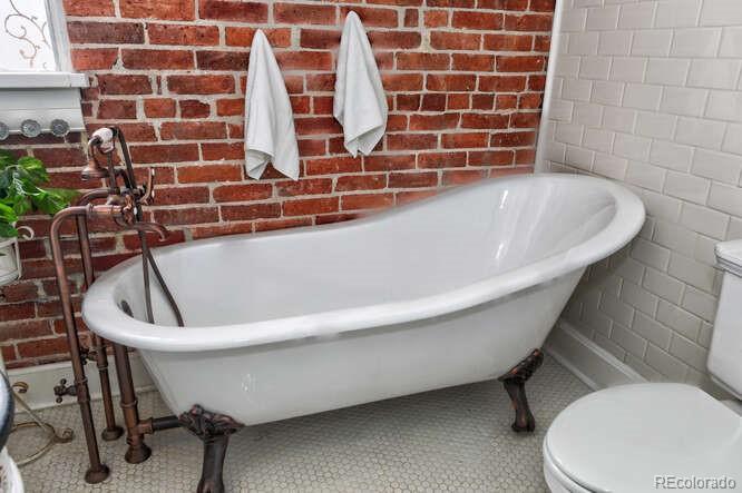 3917 Haddon Road Denver, CO 80205 - Photo 21 of 40 a bathroom with a bathtub and a sink