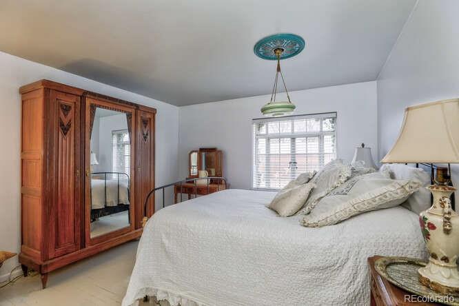 3917 Haddon Road Denver, CO 80205 - Photo 22 of 40 a bedroom with a bed and a chandelier