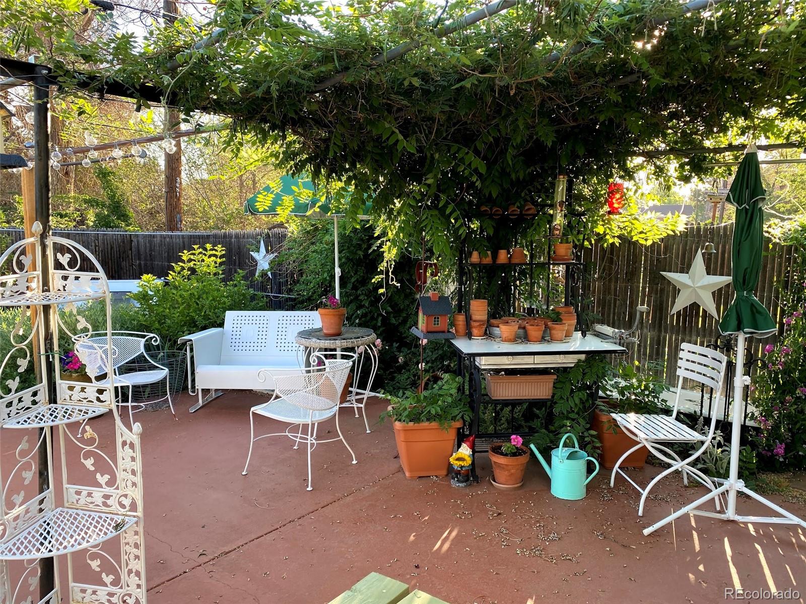 3917 Haddon Road Denver, CO 80205 - Photo 37 of 40 a backyard of a house with table and chairs plants and large tree
