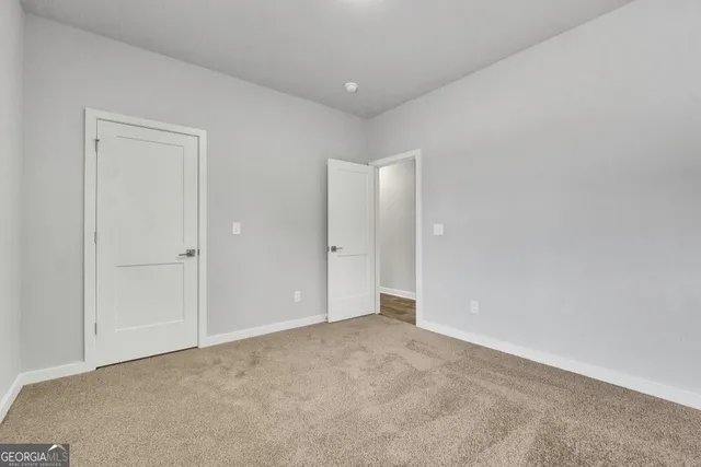 a view of an empty room and chandelier fan