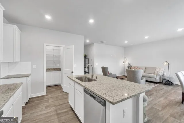 a kitchen with stainless steel appliances granite countertop a sink and a refrigerator