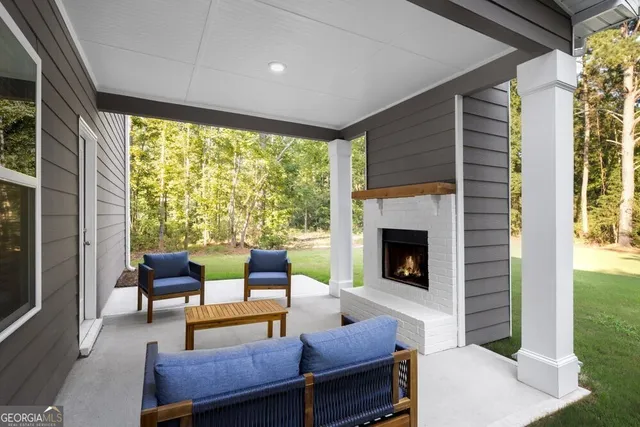 a living room with furniture a fireplace and a floor to ceiling window