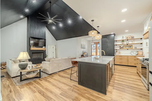 a kitchen with kitchen island granite countertop a stove and a wooden floors
