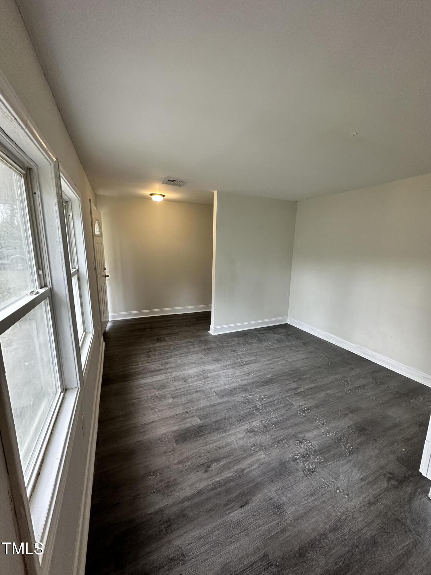 4989 Highway 217 Erwin, NC 28339 - Photo 7 of 14 an empty room with wooden floor and windows