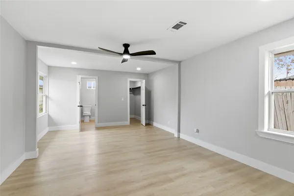 a view of empty room with wooden floor and window