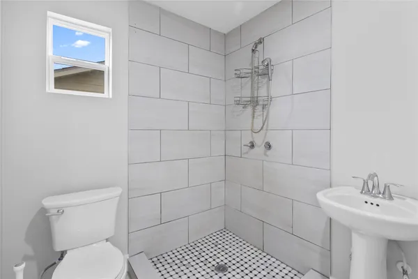 a bathroom with a toilet sink and shower