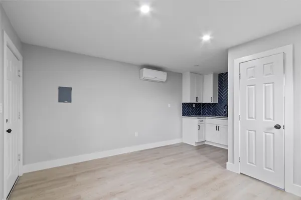 a view of a kitchen with white cabinets and wooden floor