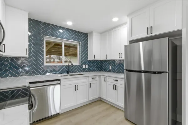 a kitchen with stainless steel appliances granite countertop a refrigerator sink and cabinets