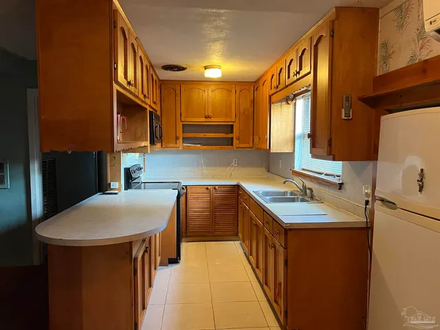 a kitchen with stainless steel appliances granite countertop a sink a stove and a refrigerator
